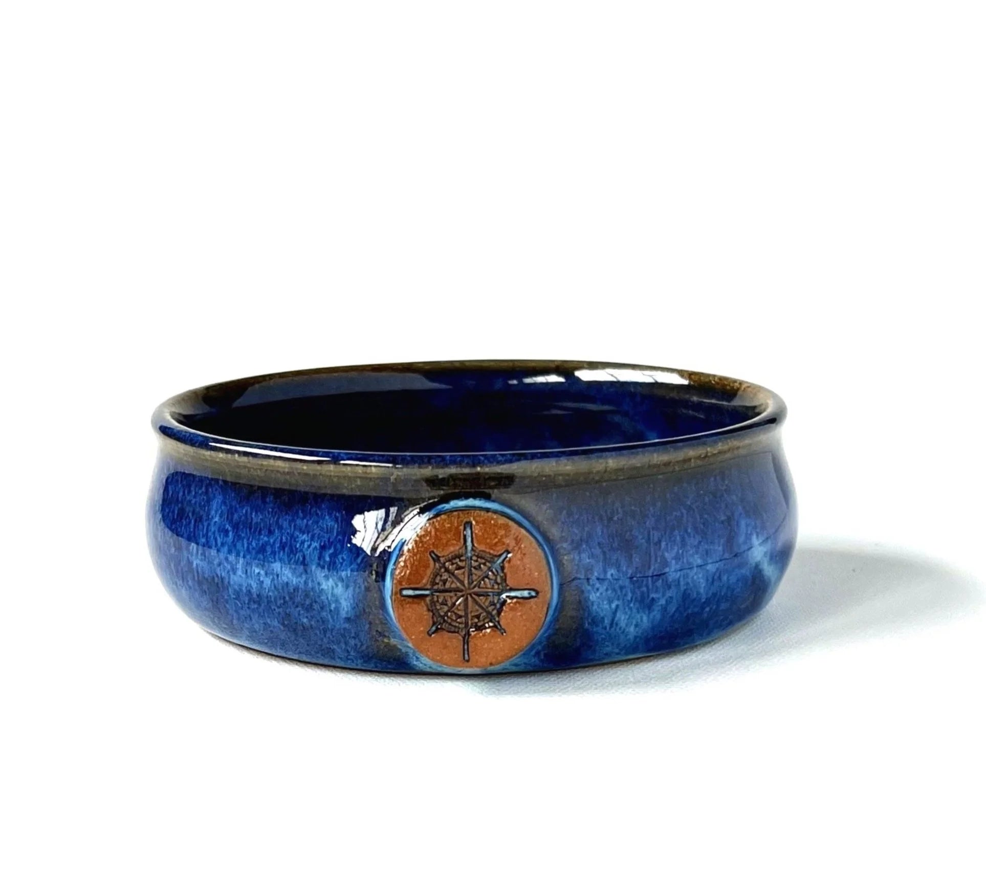 Blue ceramic bowl with a compass design on a white background